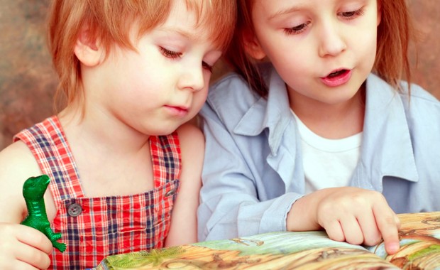 Irmãos lendo livro juntos (Foto: Shutterstock)