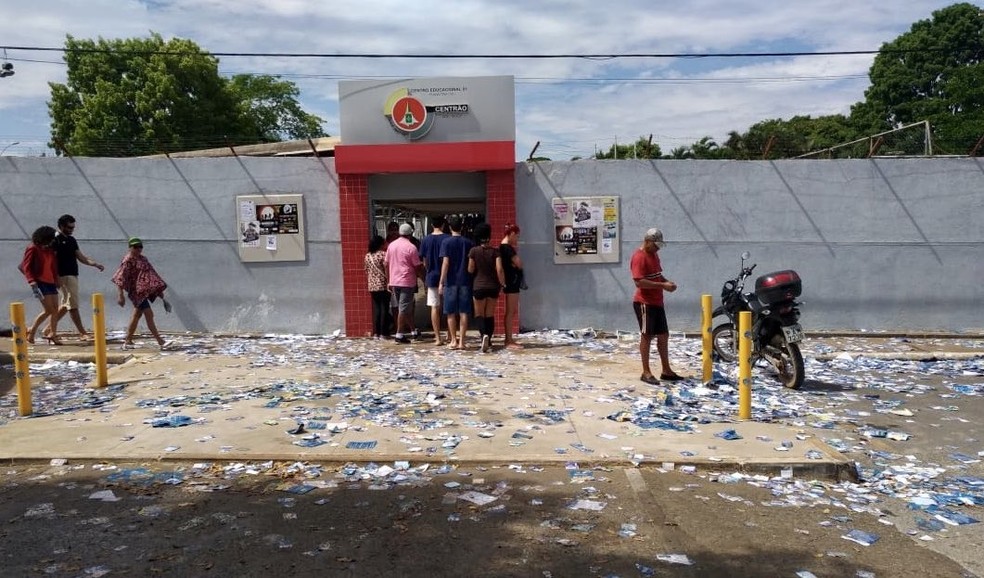 Santinhos espalhados pelo chão em frente ao Centro Educacional 1, em Planaltina — Foto: Letícia Carvalho/G1
