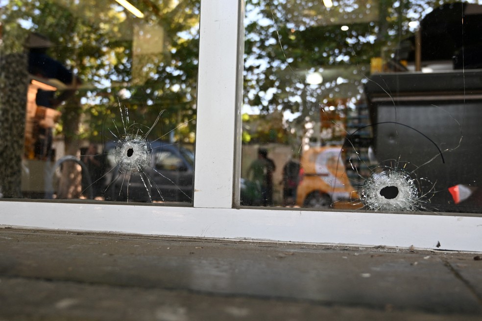 Buracos de tiros são vistos nos vidros do mercado gerenciado pela família de Antonela Roccuzzo, mulher de Lionel Messi — Foto: Luciano Bisbal/REUTERS