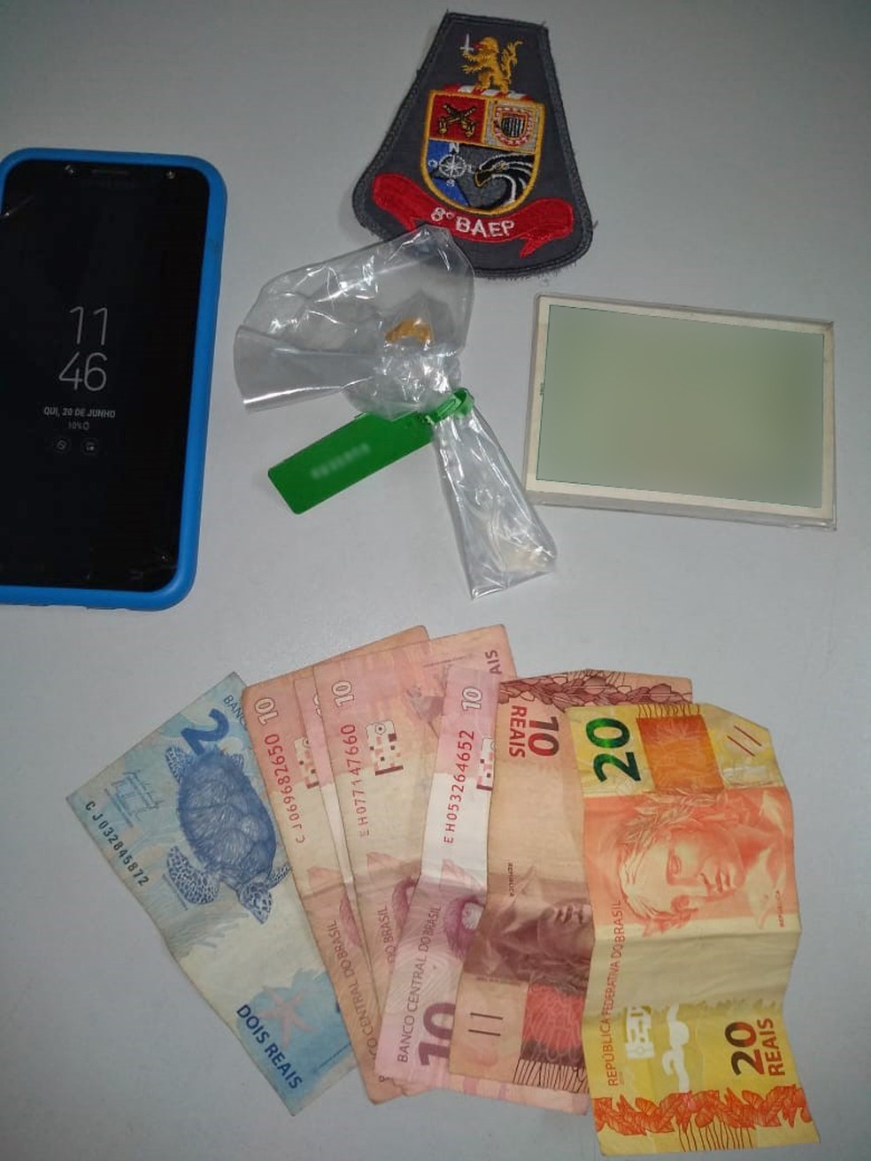 PorÃ§Ãµes de crack, celular e dinheiro foram apreendidos com o homem â€” Foto: PolÃ­cia Militar