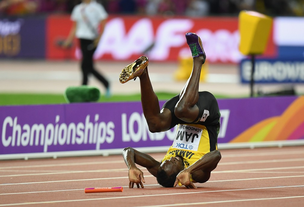 Usain Bolt deu uma cambalhota enquanto ainda tentava continuar mesmo com dores (Foto: Matthias Hangst/Getty Images)