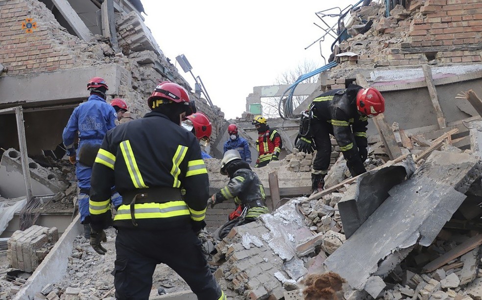Bombeiros tentam encontrar vítimas sob escombros de prédio atingido por ataque russo nos arredores de Kiev, em 22 de março de 2023. — Foto: Serviço de Emergência da Ucrânia via AP