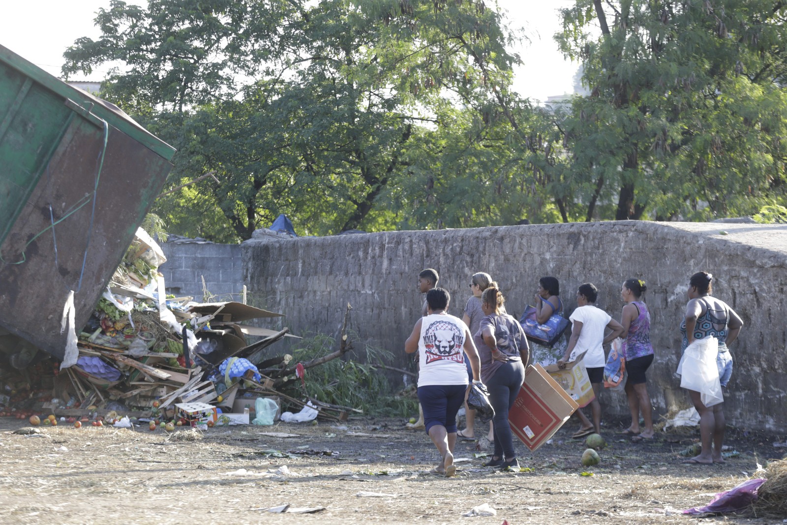 À caça de restos: pessoas buscam alimentos que ainda possam ser consumidos em meio ao descarte do Ceasa, em Irajá — Foto: Domingos Peixoto / Agência O Globo
