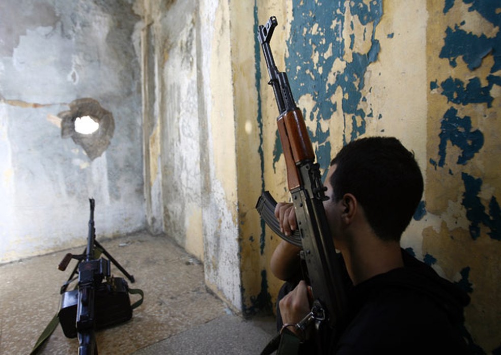 Integrante do Hezbollah se posiciona em telhado de prédio em bairro xiita de Beirute, capital do Líbano (Foto: AP )