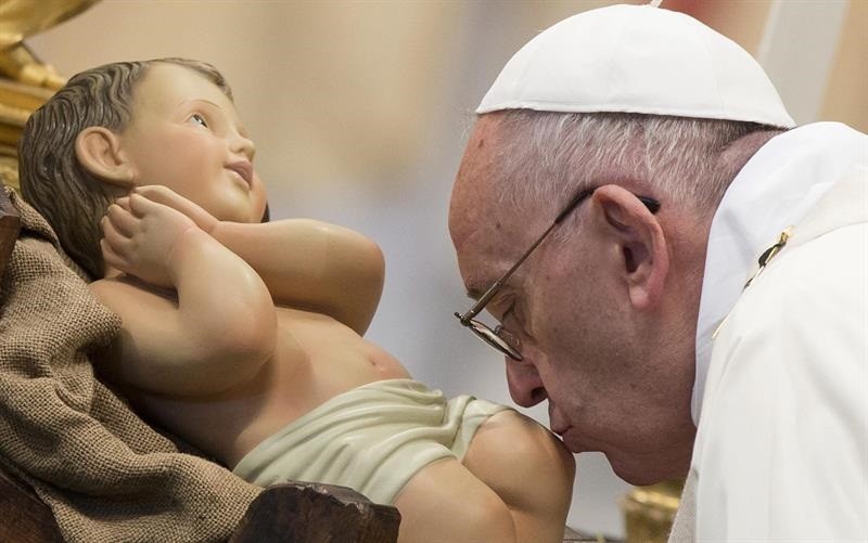 Papa Francisco beija uma estátua do bebê Jesus na Basílica de São Pedro antes de dar a missa de domingo (Foto: EFE)