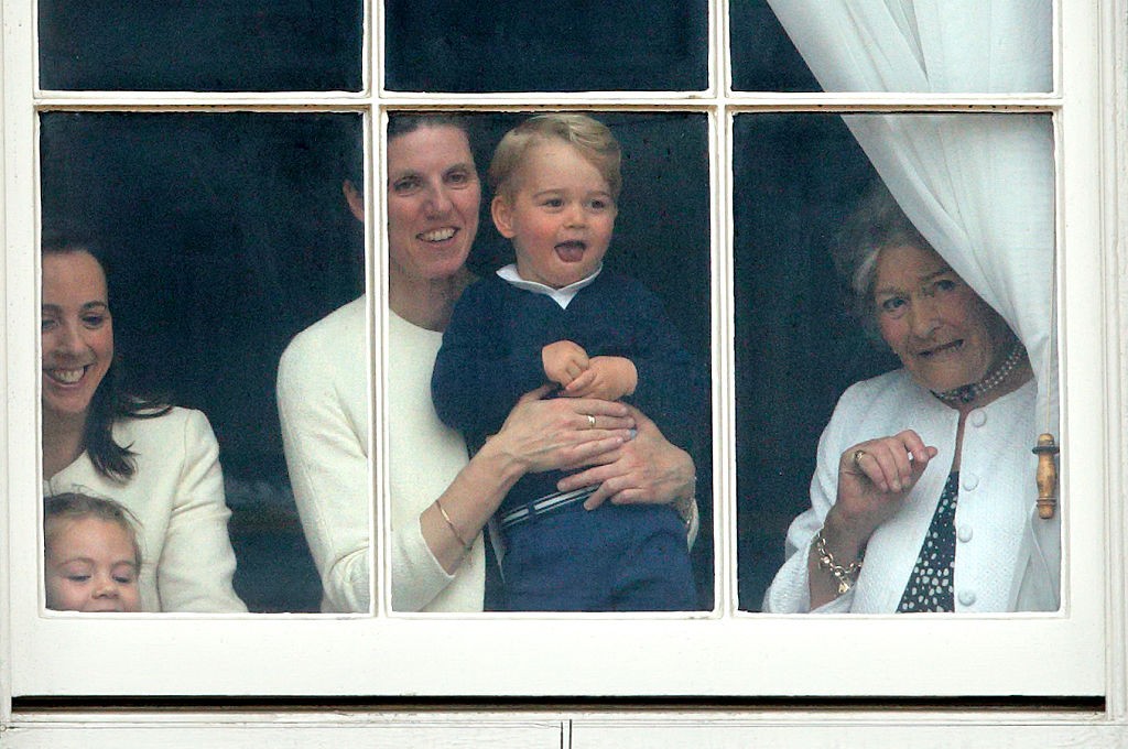 LONDON, UNITED KINGDOM - JUNE 13: (EMBARGOED FOR PUBLICATION IN UK NEWSPAPERS UNTIL 48 HOURS AFTER CREATE DATE AND TIME) Prince George of Cambridge being held up at a window of Buckingham Palace by his nanny  Maria Teresa Turrion Borrallo to watch Troopin (Foto: Getty Images)
