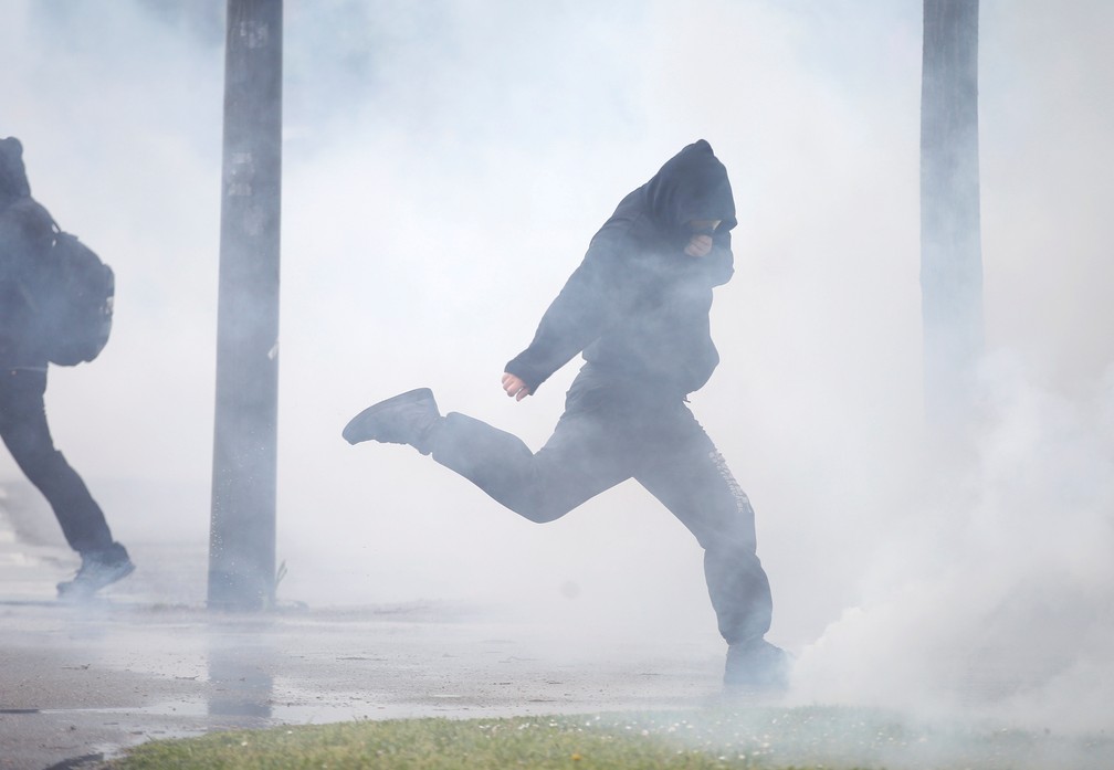 Manifestante chuta bomba de gás lançada em tumulto durante protestos coletes amarelos em Estrasburgo, na França — Foto: Vincent Kessler/Reuters