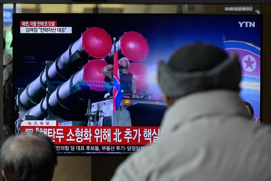 Homens assistem a uma TV com imagens de arquivo de uma parada militar norte-coreana em uma estação ferroviária em Seul