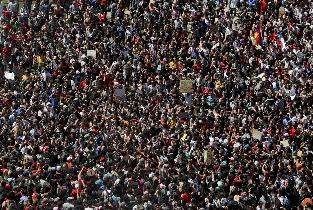 Centenas de pessoas tomam as ruas de Santiago em novo dia de protestos no Chile nesta terça-feira (22) — Foto: Esteban Felix/AP Photo