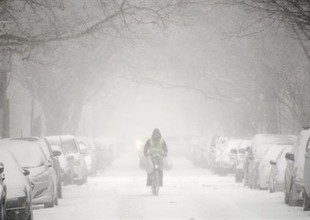 Um homem passeia de bicicleta em meio a neve de Brooklyn, Nova York (Foto: Agência EFE)