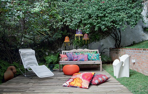 No jardim da estilista Adriana Barra, deque com espreguiçadeira. O banco tem almofadas com tecido tailandês e pufe. Presas aos galhos, lanternas chinesas de náilon compradas em viagem