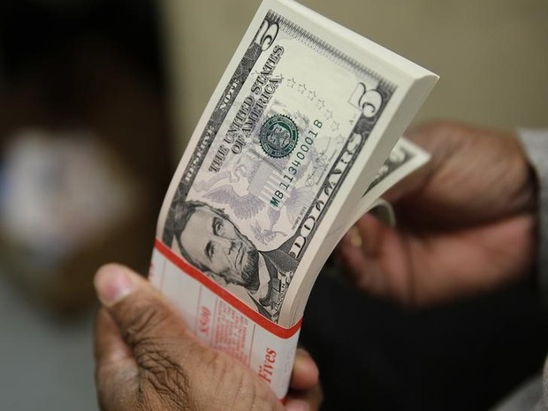 Cédulas de dólar nas mãos de uma pessoa. notas, dinheiro, dólares, cotação, câmbio, valor, economia. -HN- (Foto: Gary Cameron/Reuters)