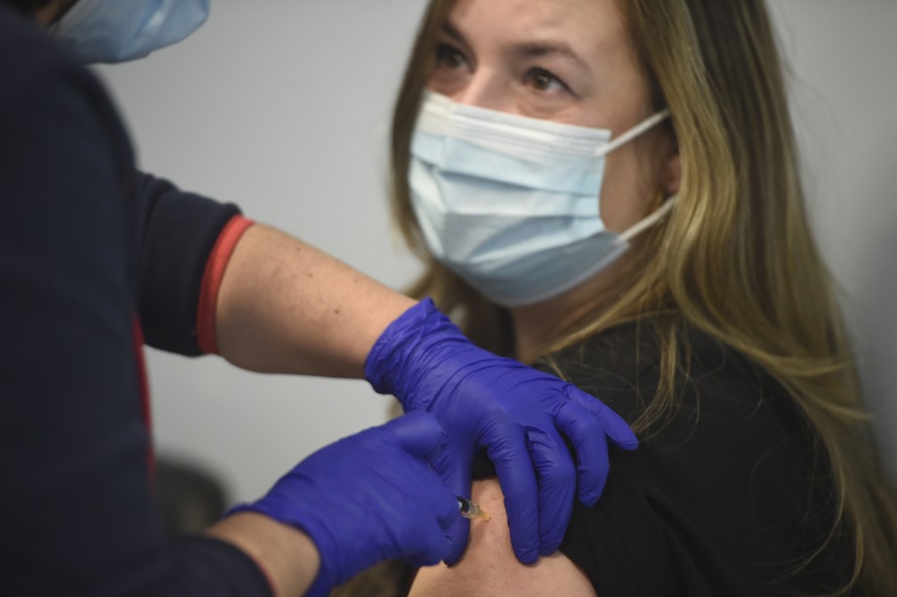 Profissional de saúde recebe vacina da Pfizer e da BioNTech no primeiro dia de imunização contra a Covid-19 em Portugal, no Hospital São João, na cidade do Porto, em 27 de dezembro de 2020 — Foto: Miguel Riopa/AFP