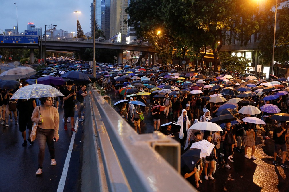 Sob forte chuva, multidÃ£o volta Ã s ruas de Hong Kong para protestar contra o governo neste domingo (18) â€” Foto: Ann Wang/Reuters