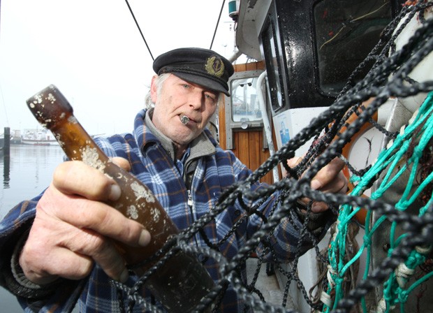 Konrad Fischer segura garrafa com mensagem jogada há 101 anos no mar da Alemanha (Foto: Uwe Paesler, DPA/AFP)