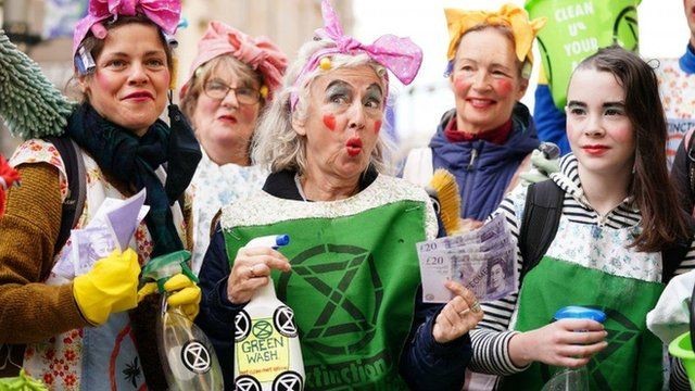 Ativistas protestam contra empresas que praticam 'greenwashing', termo usado para designar alegações falsas de benefícios ao meio ambiente (Foto: PA MEDIA via BBC NEWS)