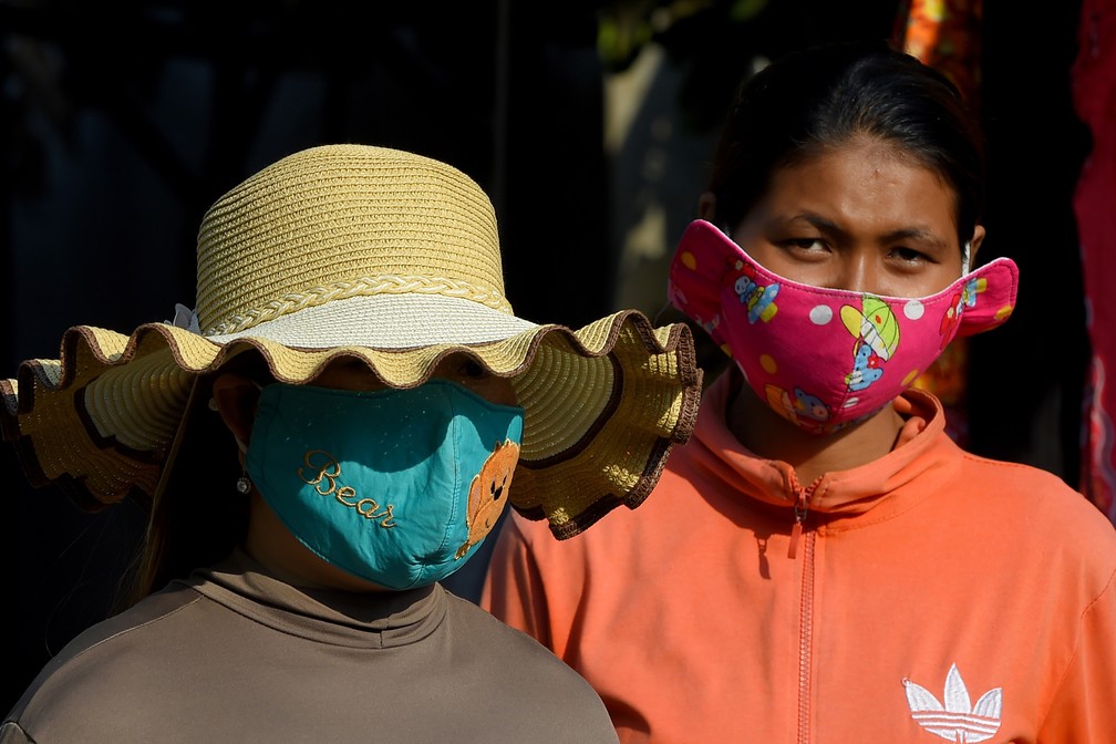 Mulheres usam máscaras de proteção como medida preventiva contra a propagação do novo coronavírus, em um mercado em Phnom Penh, no Camboja — Foto: Tang Chhin Sothy / AFP
