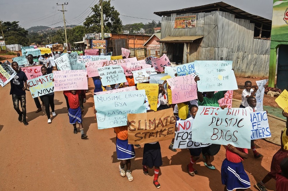 Clima: Em Akiso, Uganda, crianças levam cartazes em protesto pelo clima. — Foto: Isaac Kasamani/AFP