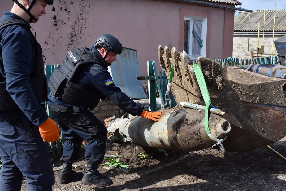 Técnicos retiram bomba russa não detonada de vilarejo na Ucrânia.