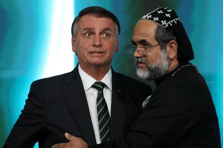 Candidato à Presidência, Padre Kelmon, do PTB, abraça o presidente Jair Bolsonaro no intervalo do debate promovido pelo SBT.