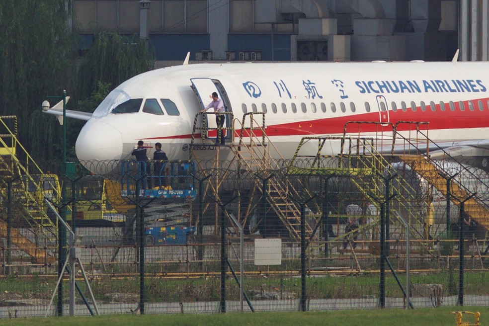 FuncionÃ¡rios inspecionam aviÃ£o que fez pouso de emergÃªncia nesta segunda-feira (14) em aeroporto de Chengdu, na China, apÃ³s janela da cabine estourar (Foto: Reuters/Stringer)