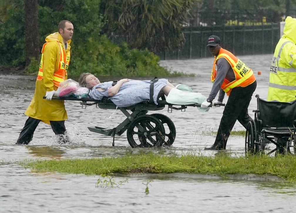 Mulher é retirada de maca de um lar de idosos em área alagada devido à passagem do furacão Ian em Orlando, na Flórida (EUA) — Foto: John Raoux/AP