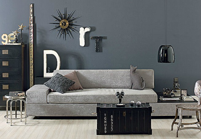 Na sala de estar, gamas de cinza e objetos rústicos deixam o ambiente com ar industrial. O baú de madeira serve como centro de mesa (Foto: Editora Globo)
