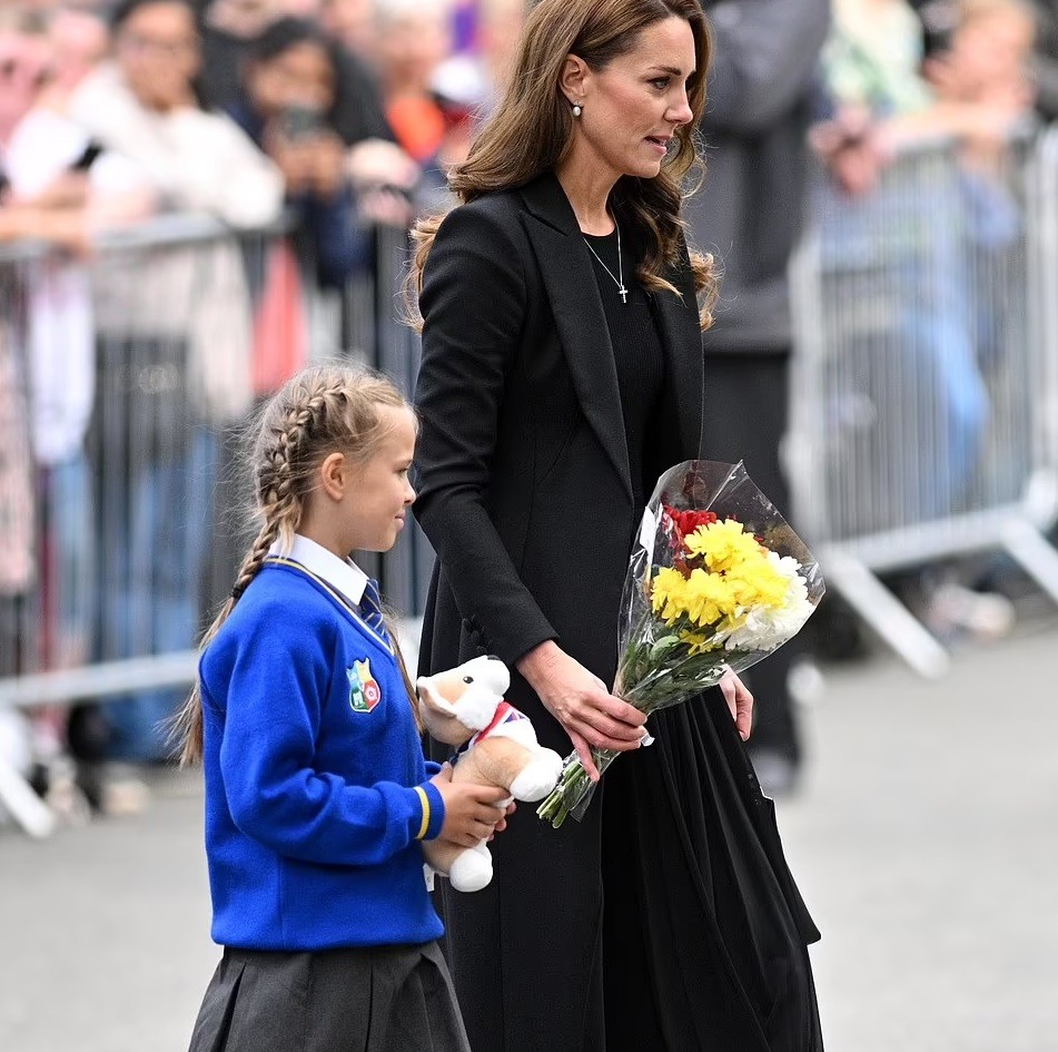 As duas caminharam juntas para deixar as homenagens da menina no tapete de flores (Foto: Reprodução/ Daily Mail)