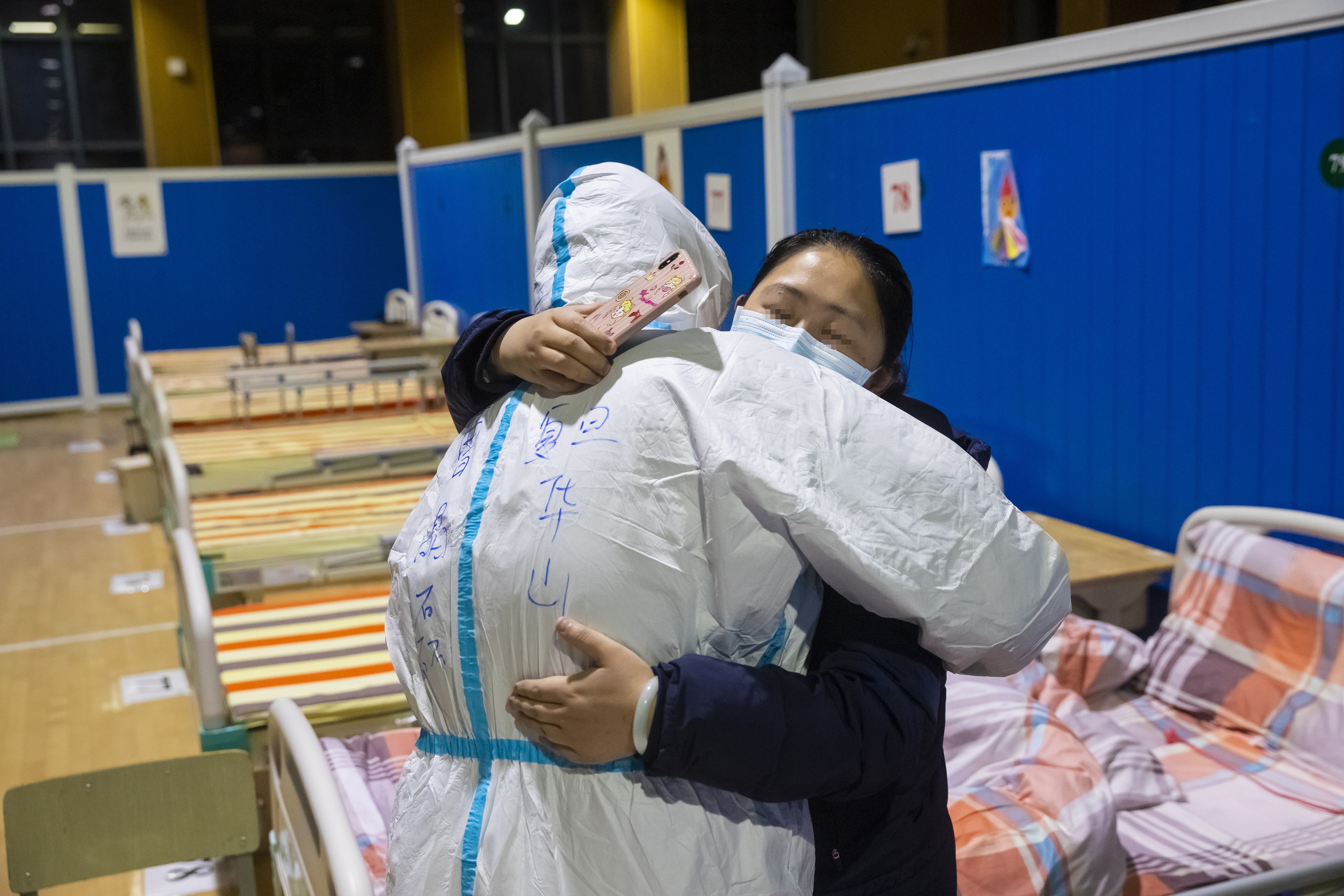 Médico e paciente se abraçam no último dia de funcionamento de hospital temporário em Wuhan (Foto: Xinhua/Xiao Yijiu)