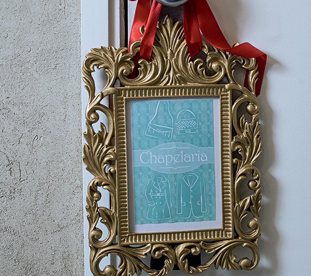 O porta-retrato dourado pendurado na porta indica a localização da chapelaria (Foto: Ricardo Corrêa/Editora Globo)