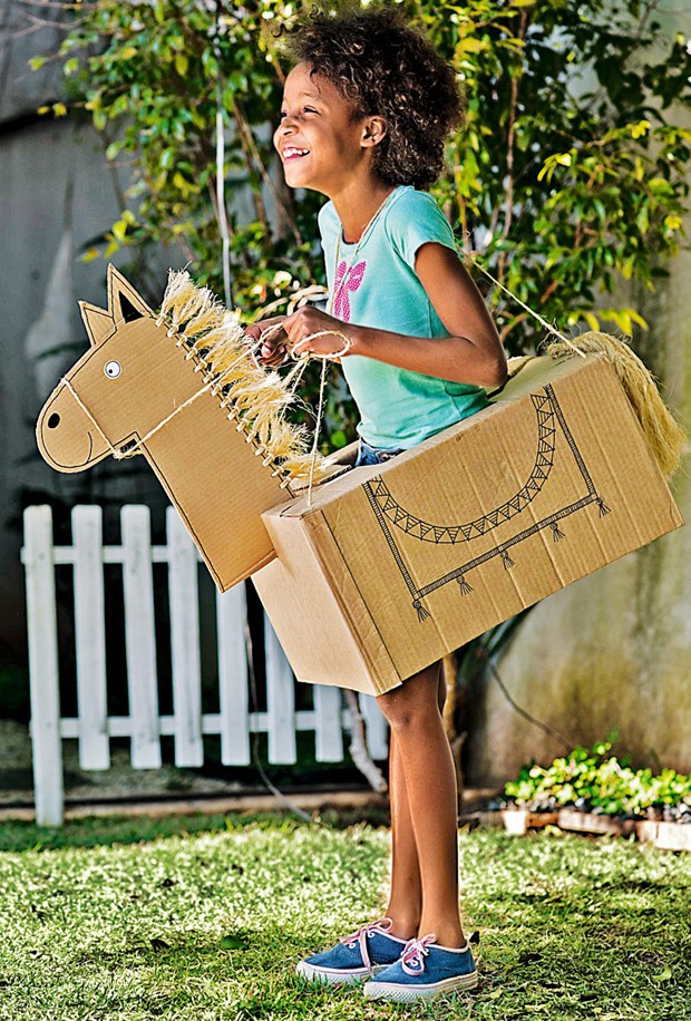 Clara se diverte como cavalo de caixas de papelão comcrina e rabo de sisal (Foto: Iara Venanzi / Editora Globo)