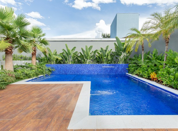 A piscina tem um jardim com tema tropical, super convidativo para um banho. No deck, piso em concreto Madeyra Vecchia, da Castelatto (Foto: Wanderley Machado / Divulgação)