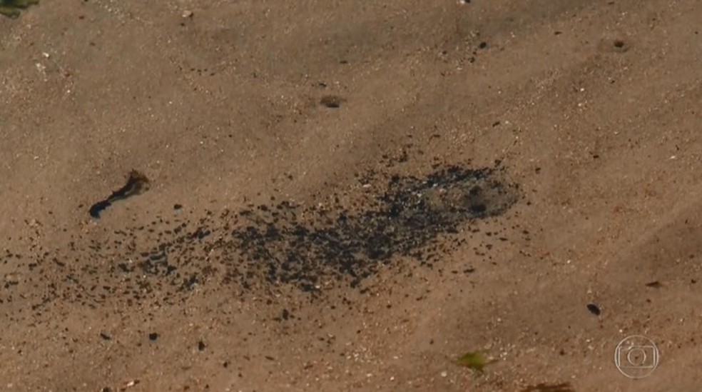 Pequenas manchas de óleo ainda são vistas na praia de Itacimirim, litoral norte da Bahia — Foto: Reprodução/ TV Globo