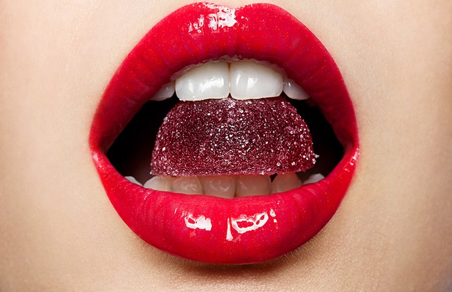 Beautiful red lips with a piece of fruit jelly (Foto: Getty Images/iStockphoto)