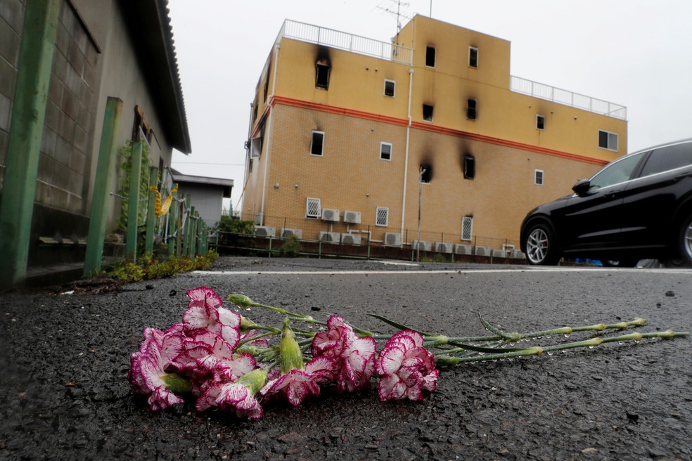 Flores são deixadas em frente ao prédio do estúdio de animação onde um incêndio matou 33 pessoas em Kyoto, no Japão, na quinta-feira (19)  — Foto: Kim Kyung-Hoon/Reuters