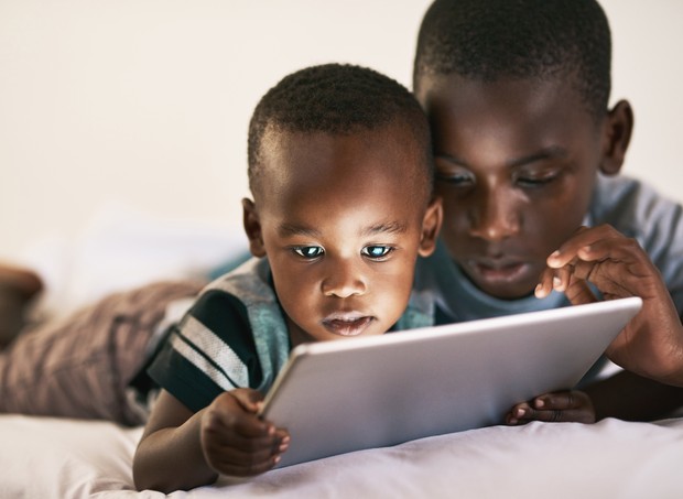 Irmãos lendo em tablet (Foto: Getty Images)