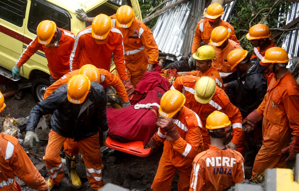 Equipe de resgate tira corpo de escombros de uma queda de muro na cidade de Pune, na Ãndia â€” Foto: Stringer/AFP