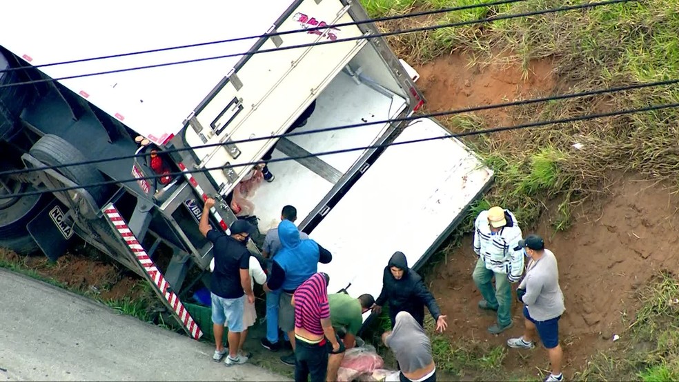 Caminhão carregado de carnes é alvo de saques após tombar em rodovia em SP — Foto: Reprodução/TV Globo