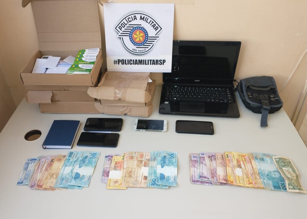 Dinheiro e objetos foram apreendidos pela polícia no apartamento dos envolvidos — Foto: Polícia Militar 