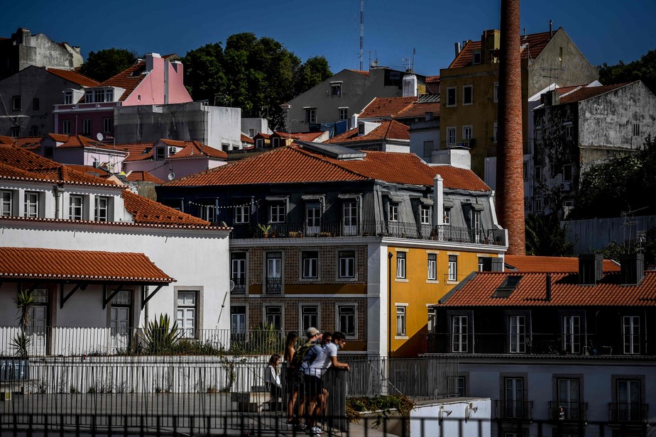 Turistas observam a paisagem em Portas do Sol, em Lisboa
