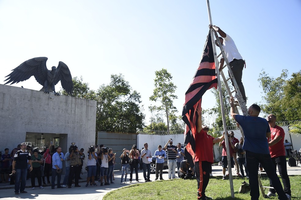 Funcion&aacute;rios colocam a bandeira a meio mastro no Ninho do Urubu &mdash; Foto: Andr&eacute; Dur&atilde;o / GloboEsporte.com