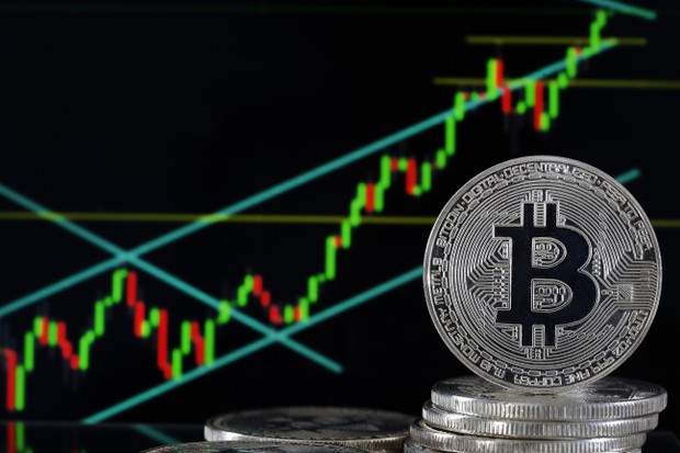 PARIS, FRANCE - JUNE 25: In this photo illustration, a visual representation of the digital Cryptocurrency, Bitcoin is displayed in front of the Bitcoin course's graph on June 25, 2019 in Paris, France. Bitcoin surpassed the 11,000 dollar mark Monday, Fac (Foto: Getty Images)
