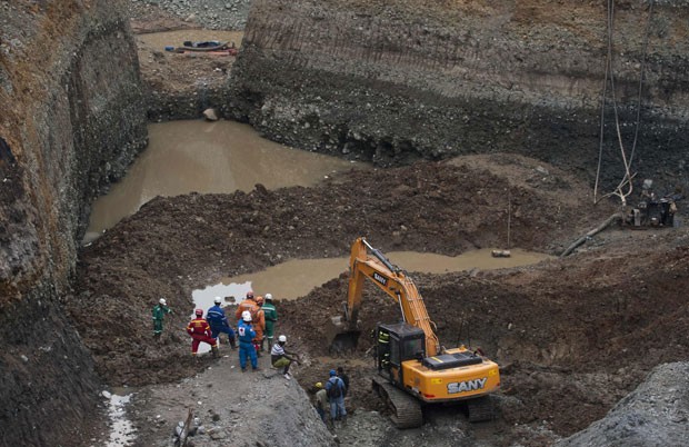 Equipe de resgate cava na mina ilegal na tentativa de resgatar os corpos dos mineiros (Foto: Luis Robayo/AFP)
