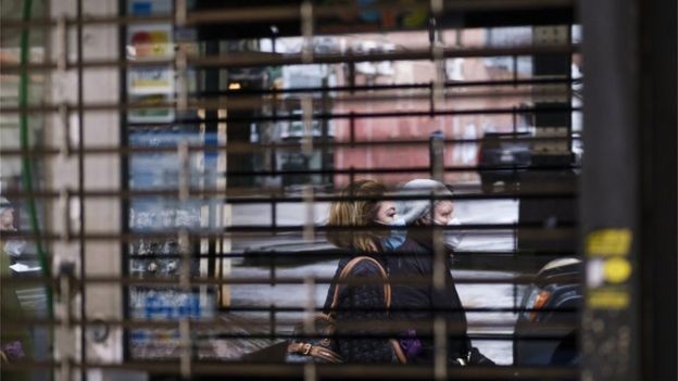 BBC - Pedestres passam em frente a comércio fechado em Nova York; professor Paolo Pasquariello, da Universidade de Michigan, diz que repercussão econômica do coronavírus nos EUA recairá fortemente sobre imigrantes (Foto: EPA/Justin Lane via BBC)