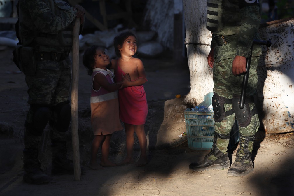 Sob os olhos de soldados mexicanos, crianças hondurenhas brincam em campo para migrantes montados no México nesta terça-feira (21) — Foto: Marco Ugarte/AP Photo
