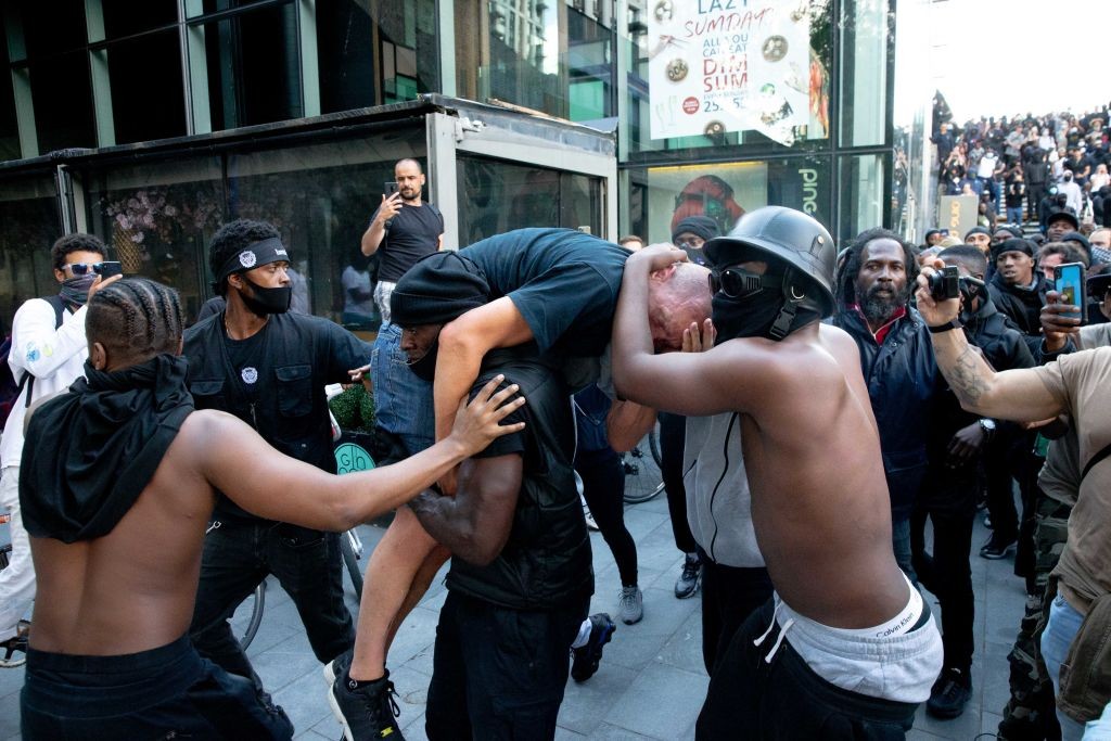 Homem negro carrega manifestante de extrema direita para evitar que ele sofresse violência (Foto: Getty Images)
