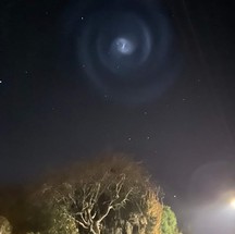 Forma espiral brilhosa e azulada causada por lançamento de foguete da SpaceX foi vista no céu da Nova Zelândia — Foto: Twitter @DigDougDigDig / Reprodução