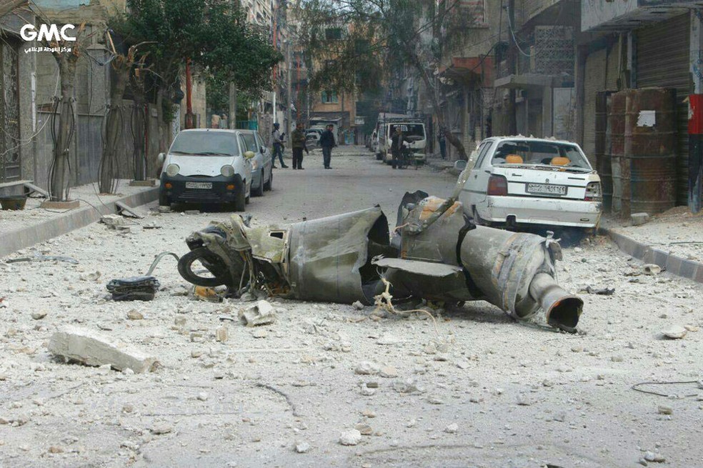 Parte de míssil que caiu em rua de Guta Oriental, na Síria, na sexta-feira (23)  (Foto: Ghouta Media Center via AP)