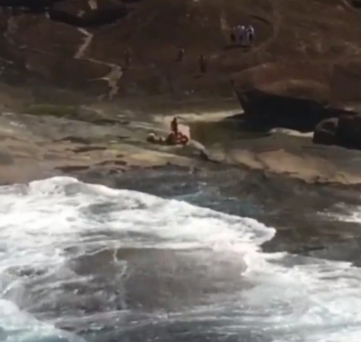 Mulher é socorrida por helicóptero após quebrar a perna em rochas na Praia das Conchas em Ubatuba