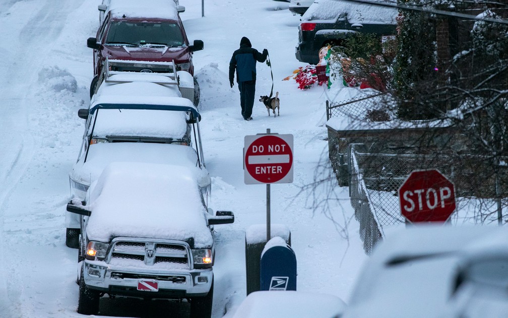 Homem passeia com cachorro por ruas cobertas de neve na Filadélfia, Pensilvânia, na quinta-feira (17) — Foto: Alejandro A. Alvarez/The Philadelphia Inquirer via AP